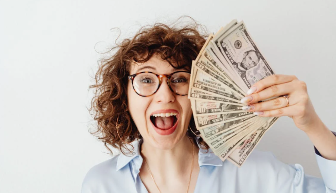 a woman holding a fan of money