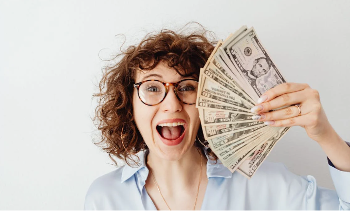 a woman holding a fan of money