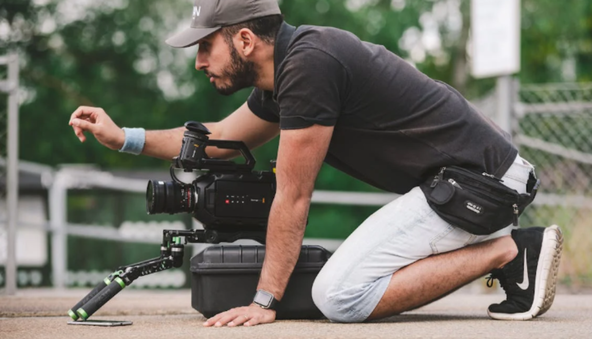 a man kneeling on the ground with a camera