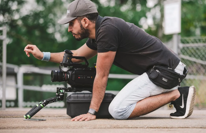 a man kneeling on the ground with a camera